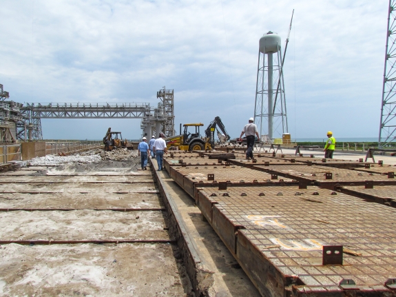 Large-format photograph: Pad Deck, Launch Complex 39-B, east side of Flame Trench, with Cutout area for Crawlerway Grid Panels exposed following their removal, where the original loose Sand which they were originally laid down upon can clearly be seen. Photo credit: Withheld by request. Photo credit: Withheld by request.